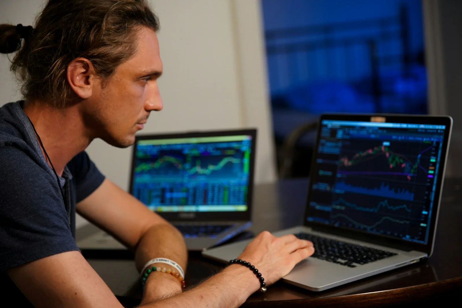 Man checking investment figures on a laptop at the kitchen table